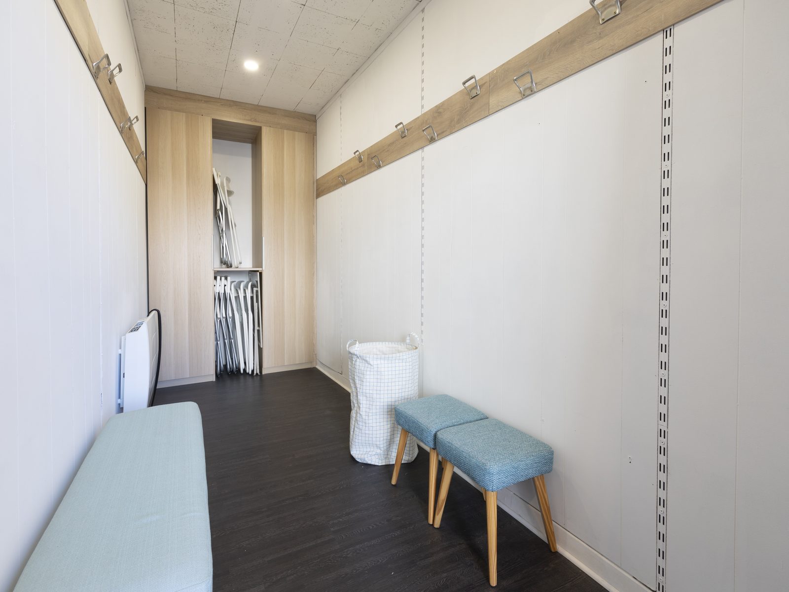 Le vestiaire et sa banquette, patères le long du mur